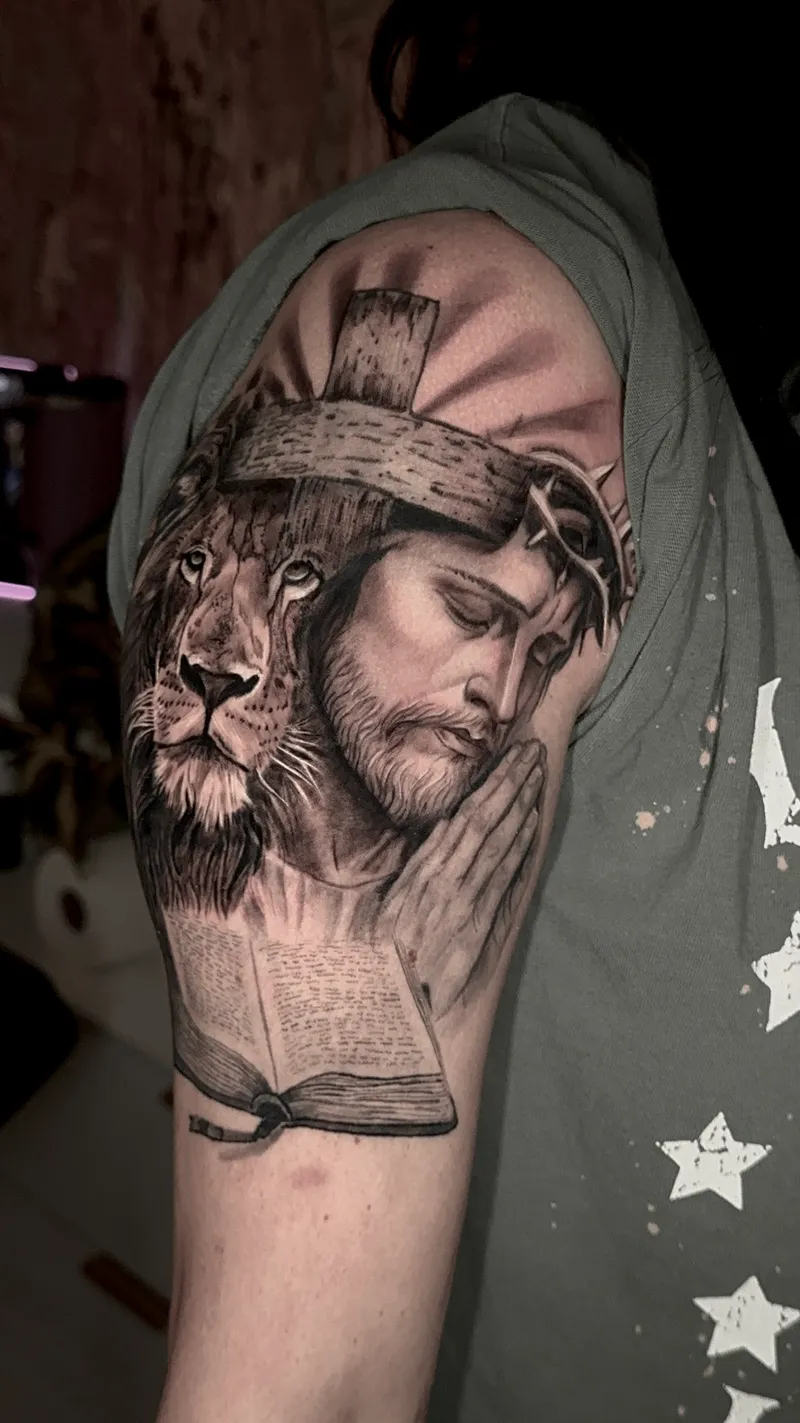 Black and grey realism tattoo of Christ and a lion on the upper arm