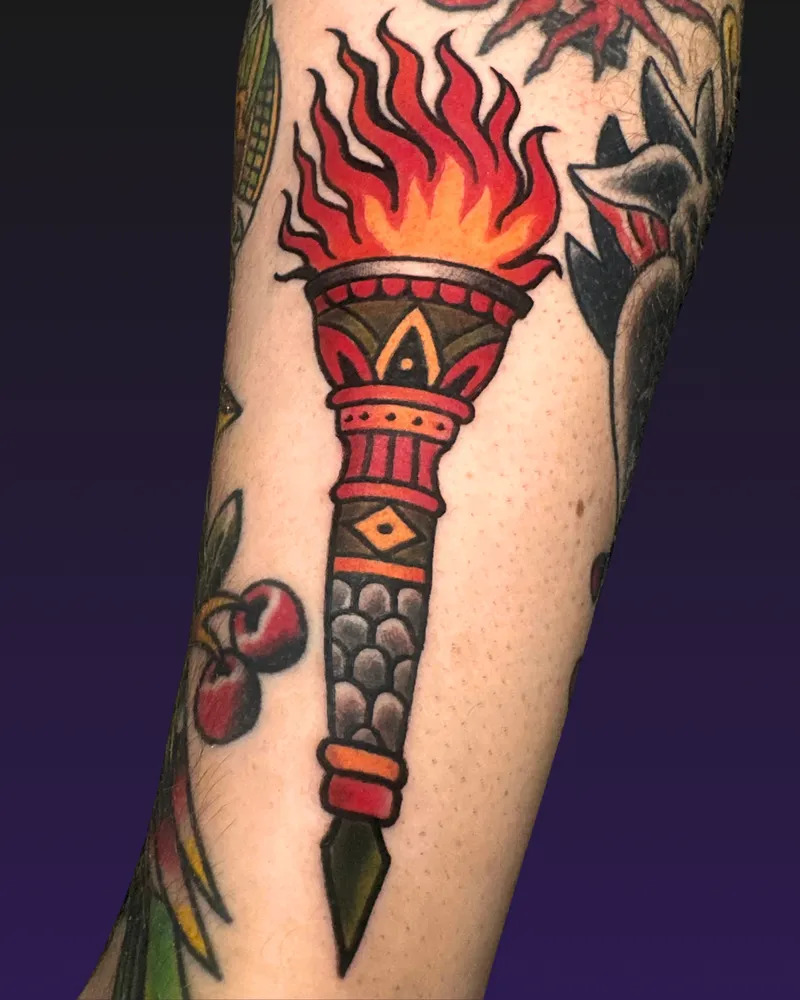 Traditional torch with flames, cherries and leaves on the forearm